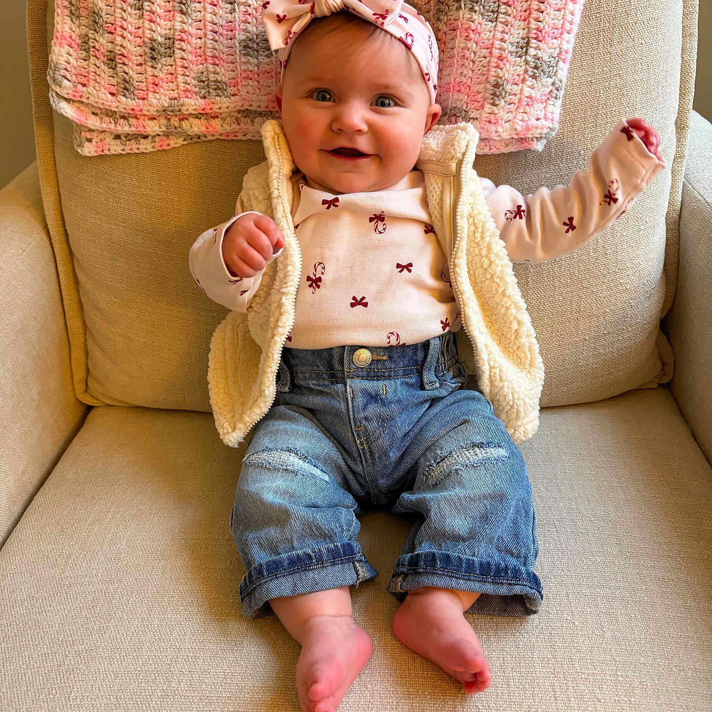 Leighton Shaw joined the competition — help win amazing prizes! armchair, baby, barefoot, bow, child, comfortable, cozy, cute, denim_jeans, happy, headband, indoor, infant, knitted_blanket, long_sleeve_shirt, portrait, seated, smiling, vest, warm_colors