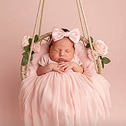 Alara Urtecho joined the competition — help win amazing prizes! baby, infant, sleeping, pink, dress, bow, flower, roses, basket, hanging, soft_background, cute, peaceful, newborn, portrait, child, hands_folded, studio_photo, decorative, fabric
