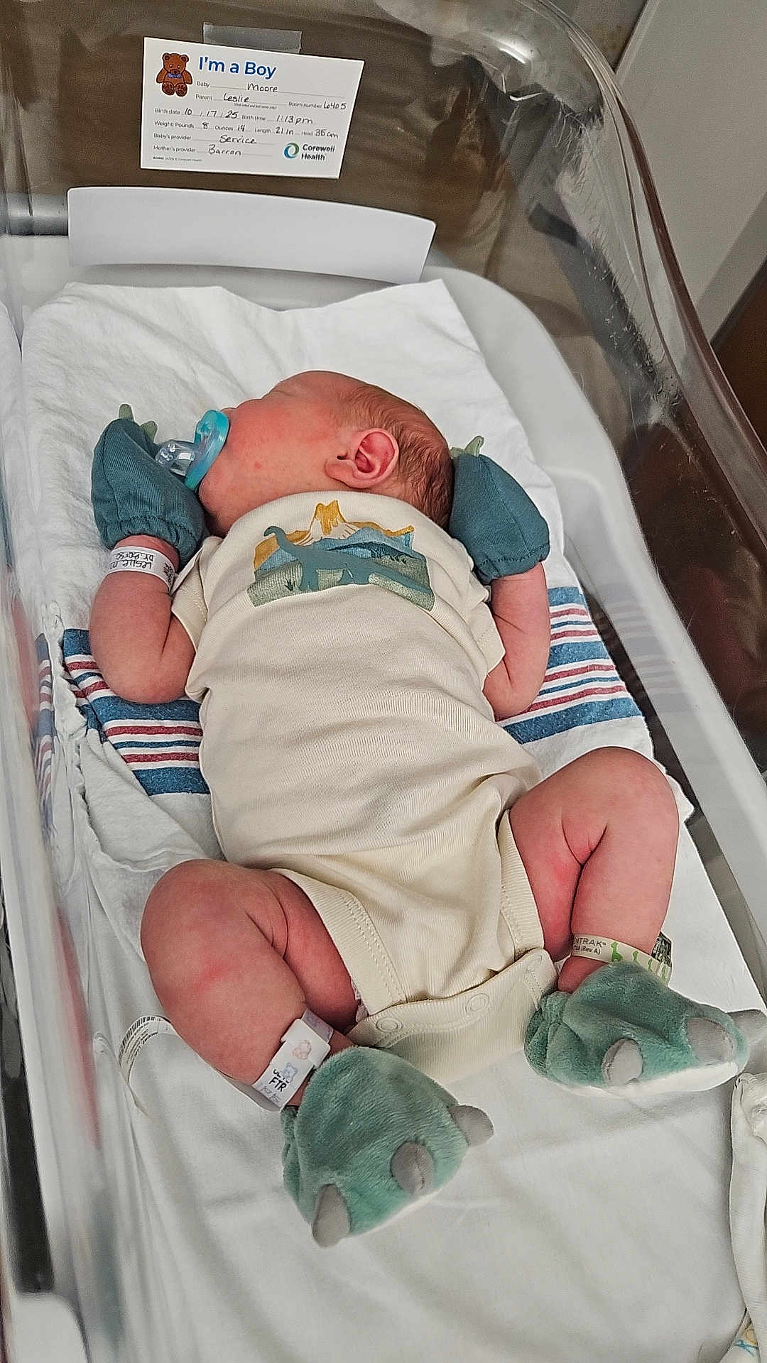 Jasper is registered to the contest to win money with this photo: baby, bassinet, bed, blanket, booties, child, clothing, cute, dinosaur, healthcare, hospital, hospital_id, infant, mittens, newborn, onesie, pacifier, patient, resting, sleeping