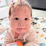 Léna participe au concours pour gagner de l'argent avec cette photo : baby, child, face, eyes, hair_clips, book, blanket, indoor, cute, infant, clothing, pattern, floor, toy, person, portrait, expression, playful, curious, young