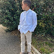 Aarôn participe au concours pour gagner de l'argent avec cette photo : beige_pants, boots, boy, bushes, casual_pose, chain_necklace, child, cool_style, daylight, greenery, hands_in_pockets, leaves, nature, outdoor, pavement, short_hair, side_view, standing, sunglasses, white_shirt