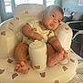 baby, infant, child, inflatable_chair, teddy_bear_pattern, indoor, living_room, couch, window, daylight, curious_expression, barefoot, onesie, soft_lighting, cozy, furniture, person, seat, foot, head