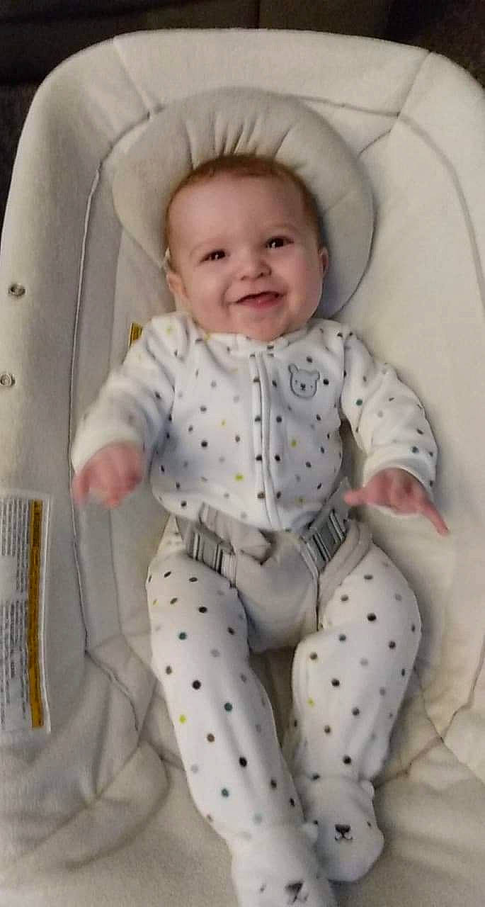 Bryant is registered to the contest to win money with this photo: baby, baby_products, baby_safety, baby_toddler_clothing, cheek, child, comfort, facial_expression, joy, laugh, mouth, nose, overall, pattern, person, polka_dot, product, sitting, sleeve, smile