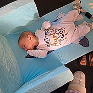 Elijah joined the competition — help win amazing prizes! baby, infant, onesie, blue_changing_pad, baby_sandals, footwear, slippers, floor, person, child, lying_down, indoor, clothing, baby_gear, cute, sleepwear, text_on_clothing, human, newborn, baby_boy
