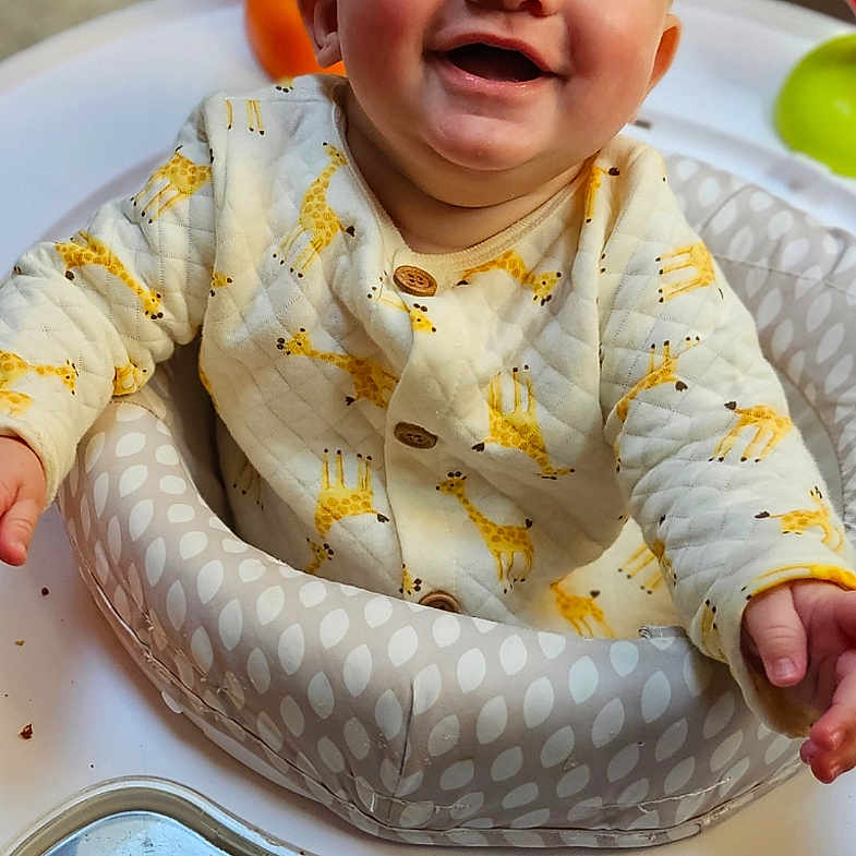 Hayde is registered to the contest to win money with this photo: baby, infant, smile, giraffe_pattern, baby_walker, child, happy, cute, indoor, clothing, seat, playtime, person, young_child, joyful, portrait, sitting, head, face, expression
