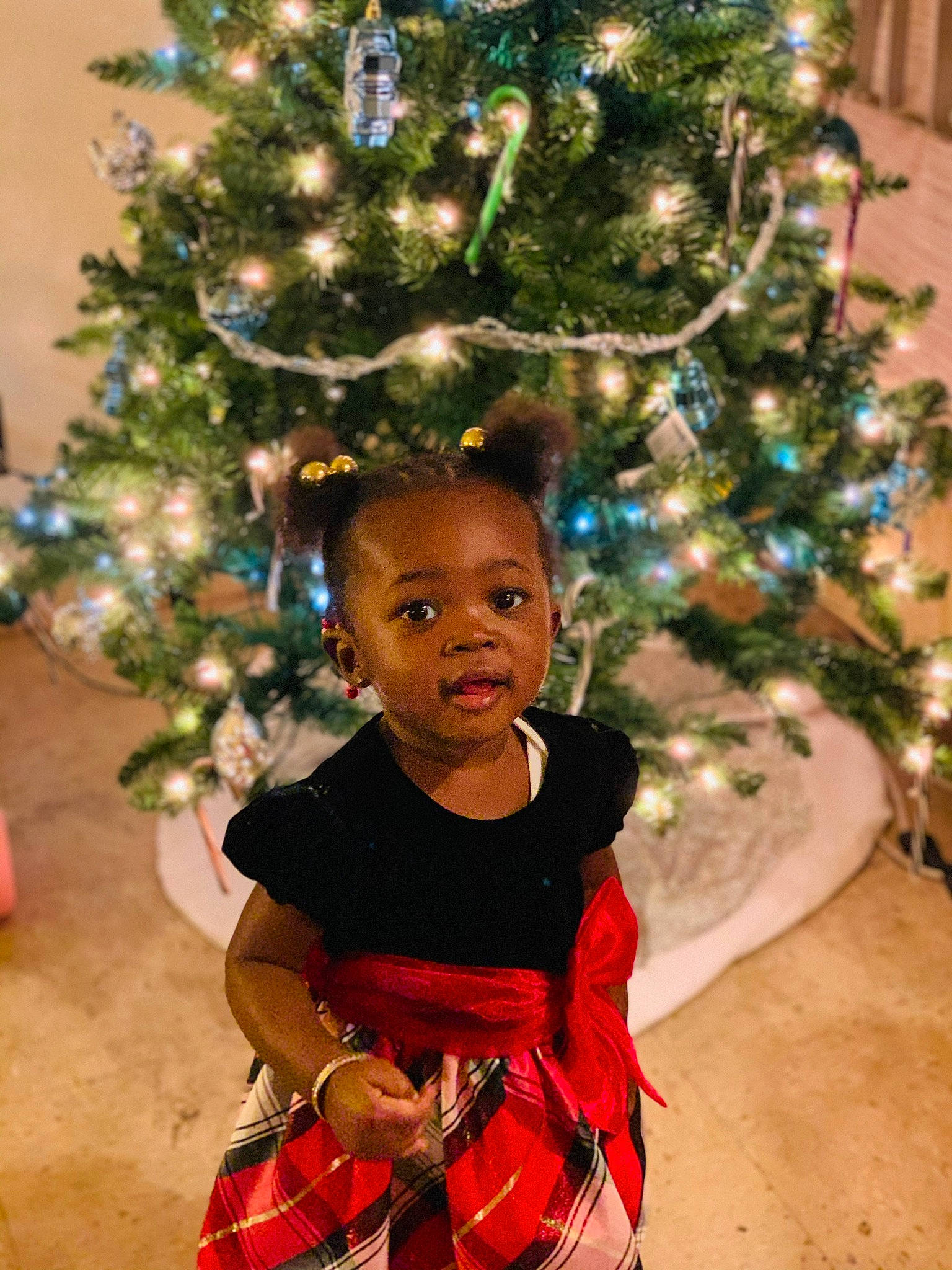 Jurnee is registered to the contest to win money with this photo: child, christmas, christmas_decoration, christmas_eve, christmas_ornament, christmas_tree, conifer, event, fir, fun, holiday, holiday_ornament, interior_design, person, pine_family, plant, smile, toddler, tradition, tree