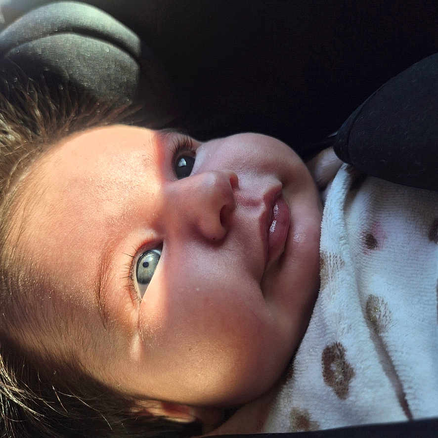 Chiara a rejoint le concours — aidez-le/la à gagner de superbes lots ! baby, infant, face, blue_eyes, blanket, polka_dots, close_up, portrait, cute, child, newborn, soft_light, cozy, expression, smile, skin, hair, indoors, car_seat, young