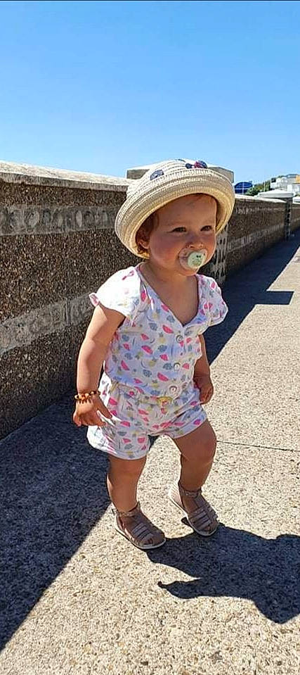 Romy a rejoint le concours — aidez-le/la à gagner de superbes lots ! baby, baby_toddler_clothing, cap, dress, eyewear, fun, happy, hat, headgear, headwear, leisure, pattern, person, sandal, skin, sky, sleeve, standing, summer, sun_hat
