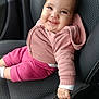 baby, smiling, car_seat, child, pink_clothing, hoodie, shorts, hand, seatbelt_buckle, interior, car, happy, cute, portrait, infant, young_child, sitting, face, person, casual