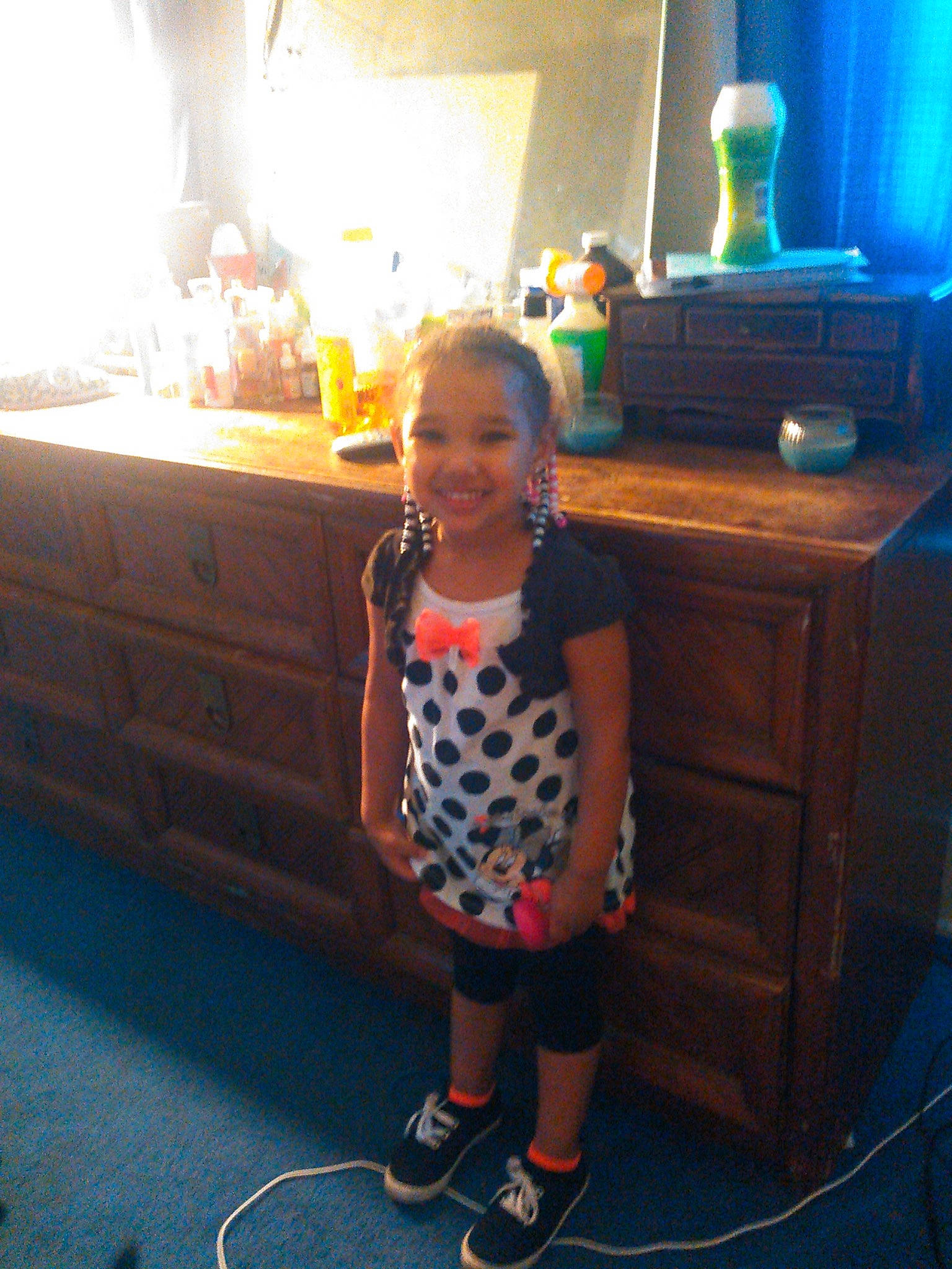 Honesty is registered to the contest to win money with this photo: cabinetry, chest_of_drawers, child, countertop, drawer, dresser, electric_blue, floor, flooring, fun, joy, kitchen, person, room, sandal, shorts, smile, standing, t_shirt, table