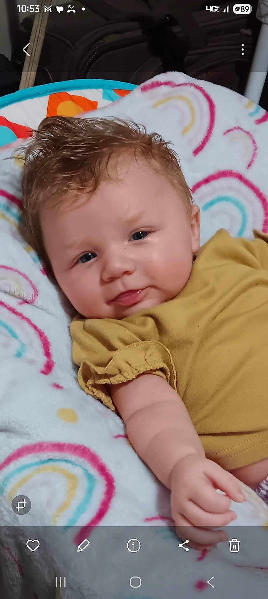Bonnie joined the competition — help win amazing prizes! baby, infant, child, smile, face, blue_eyes, hair, blanket, rainbow_pattern, mustard_clothing, arm, cute, indoors, soft_texture, portrait, skin, hand, comfort, lying_down, happy