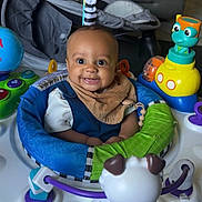 Zion joined the competition — help win amazing prizes! activity_center, baby, blue, child, clothing, colorful, face, floor, green, happy, head, indoor, infant, orange, person, play, seat, smiling, toy, yellow