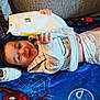 Jaxton is registered to the contest to win money with this photo: baby, diaper, blanket, blue, smiling, indoor, couch, remote_control, shoe, holding, person, child, happy, clothing, toy, spiderman, fabric, home, cute, resting