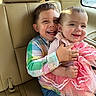 baby, car_interior, car_seat, checkered_shirt, child, children, clothing, cute, family, happy, hug, indoor, joy, pink_dress, portrait, seatbelt, sibling, smile, sunlight, window