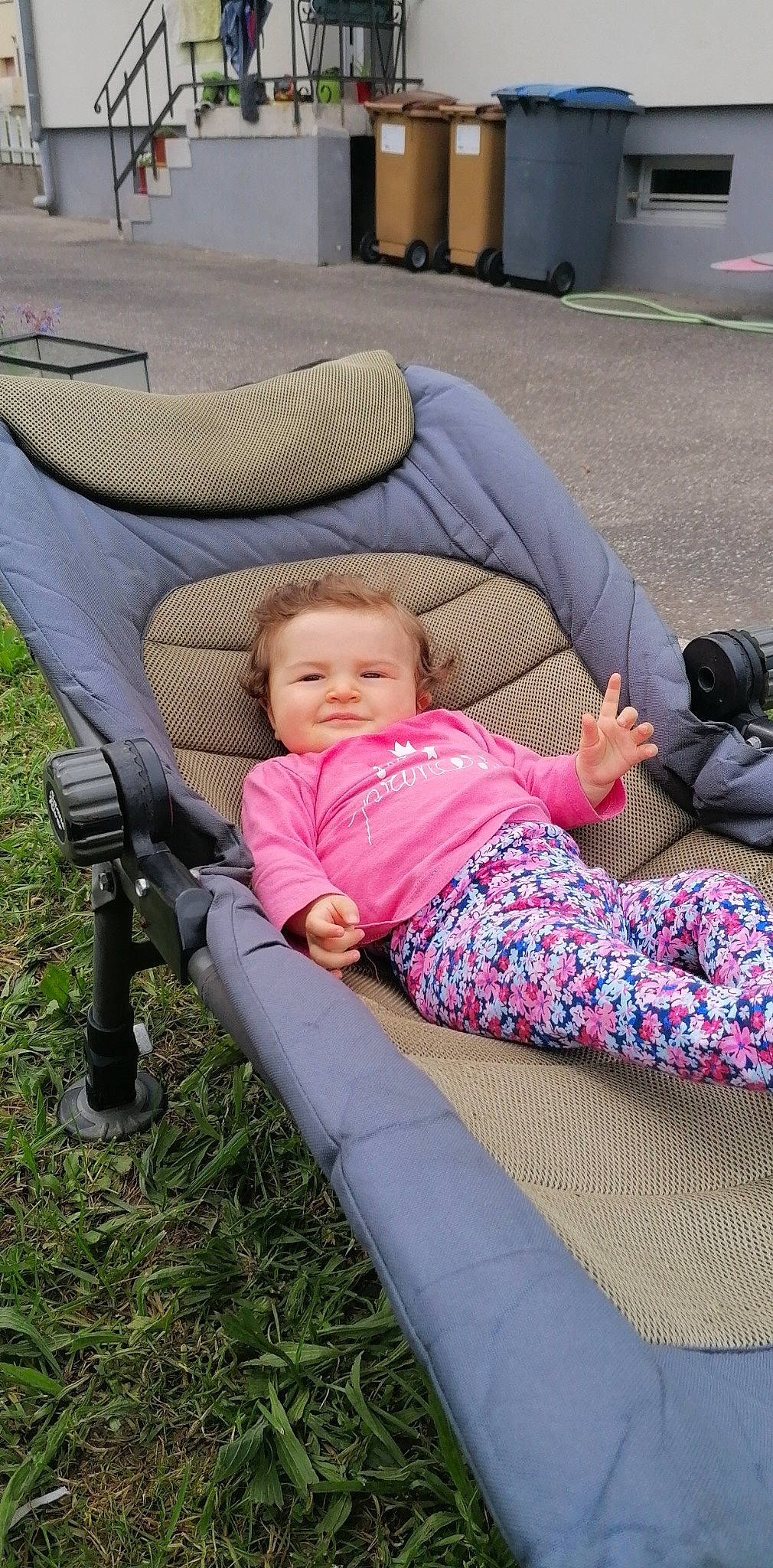 Elyna participe au concours pour gagner de l'argent avec cette photo : baby, baby_carriage, baby_products, baby_toddler_clothing, camera, child, comfort, fun, grass, lap, lawn, leisure, magenta, mammal, outdoor_furniture, person, product, recreation, sitting, smile