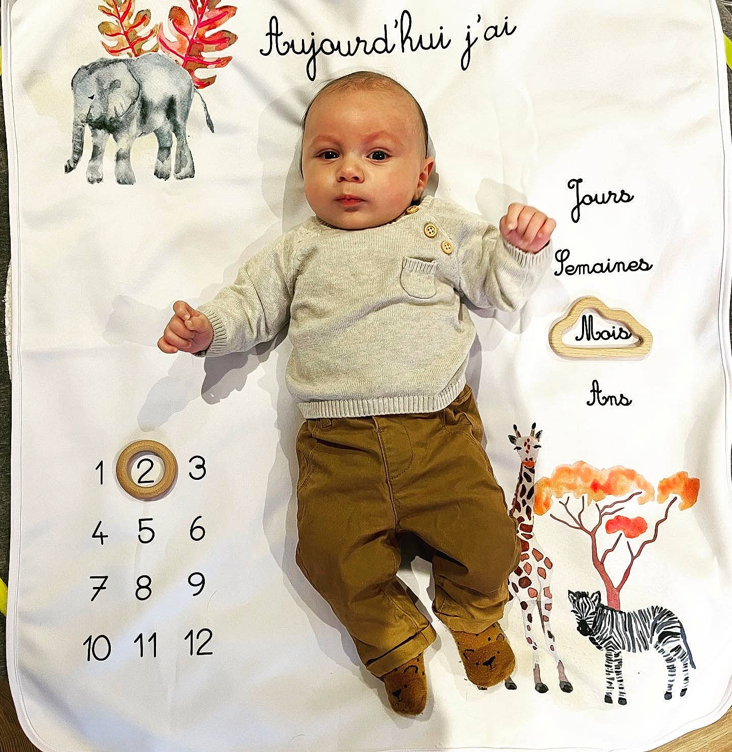 Louis participe au concours pour gagner de l'argent avec cette photo : arm, baby, baby_toddler_clothing, child, design, face, facial_expression, font, gesture, happy, linens, mammal, outerwear, pattern, person, product, sleeve, t_shirt, textile, toddler