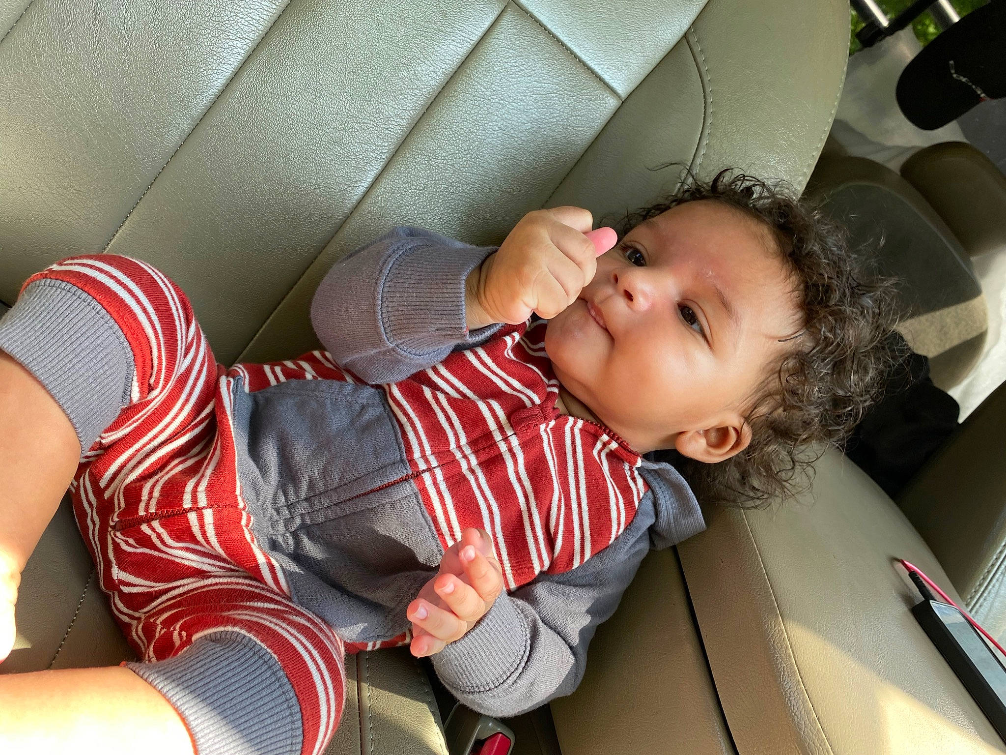 Braxtyn is registered to the contest to win money with this photo: automotive_design, baby, baby_carriage, baby_products, baby_toddler_clothing, car_seat, child, comfort, facial_expression, fun, human_leg, knee, mouth, pattern, person, plaid, sitting, skin, smile, thigh