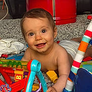 Léna a rejoint le concours — aidez-le/la à gagner de superbes lots ! baby, smiling, toys, colorful, indoor, floor, play, child, diaper, happy, cute, person, hand, face, eyes, wooden_floor, fabric, plastic, red, blue
