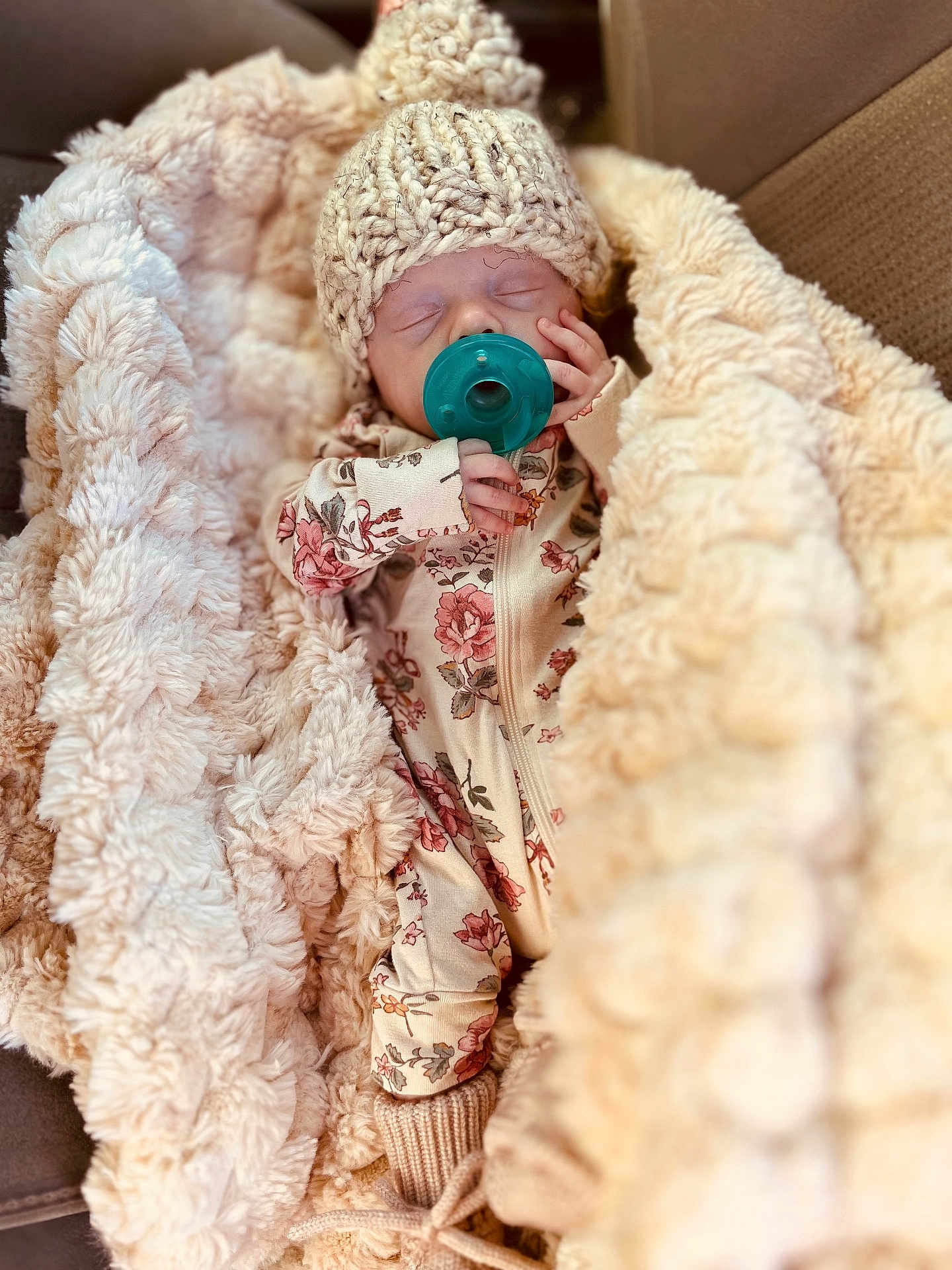 Theron is registered to the contest to win money with this photo: baby, sleeping, pacifier, knit_hat, blanket, floral_onesie, cozy, infant, soft_texture, cute, resting, warm, hand, face, newborn, fabric, comfort, indoor, portrait, child