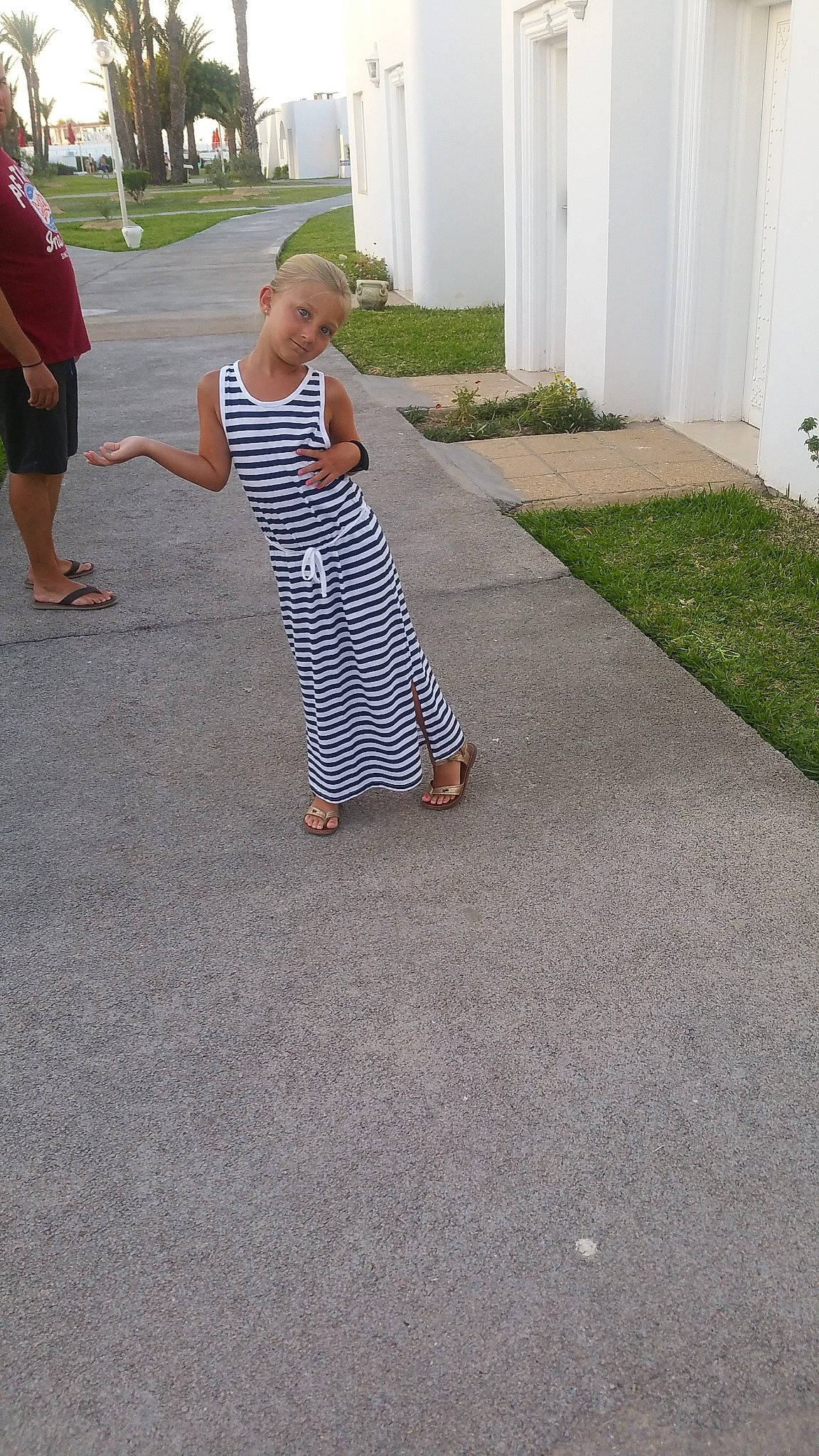 Kloé a rejoint le concours — aidez-le/la à gagner de superbes lots ! asphalt, child, day, floor, flooring, footwear, grass, leg, person, photograph, plant, play, public_space, recreation, road_surface, shoe, sidewalk, sitting, snapshot, vacation