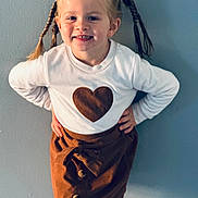 Iris a rejoint le concours — aidez-le/la à gagner de superbes lots ! child, girl, smiling, braids, pigtails, white_sweater, heart, brown_skirt, buttons, standing, posing, indoor, wall, happy, cute, fashion, portrait, young, person, clothing