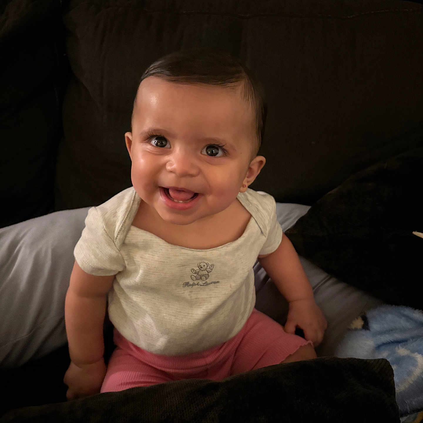 Genesis Rose is registered to the contest to win money with this photo: baby, blanket, child, clothing, couch, cute, face, happy, head, indoor, infant, joy, onesie, person, pillow, portrait, shorts, sitting, smile, young