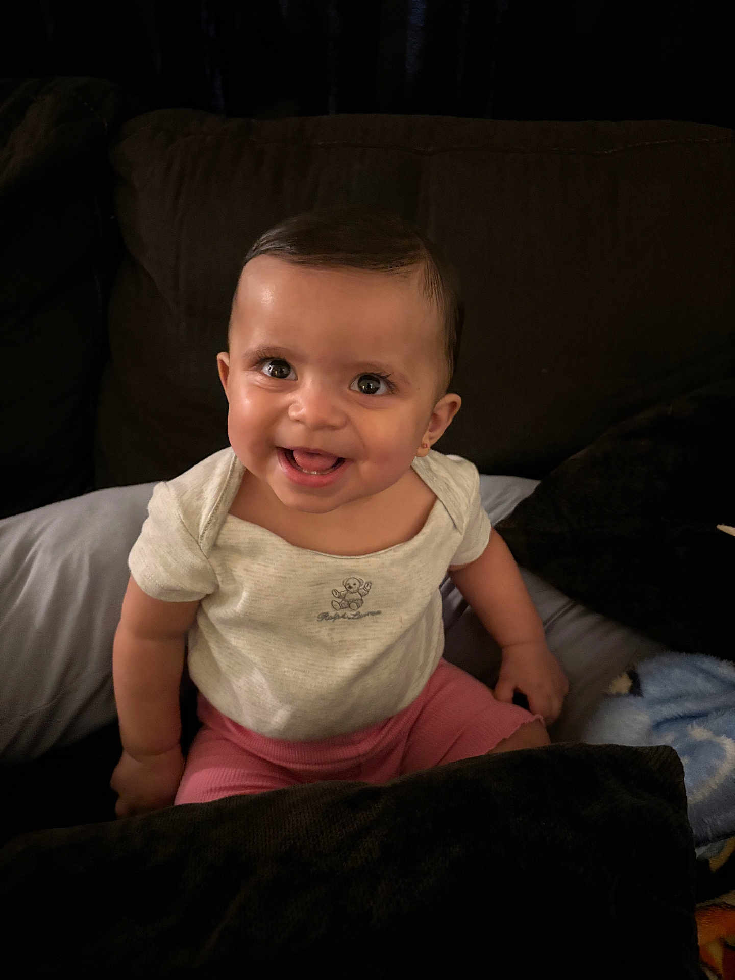 Genesis Rose is registered to the contest to win money with this photo: baby, smile, child, indoor, couch, pillow, blanket, happy, person, sitting, cute, infant, clothing, shorts, onesie, face, head, young, joy, portrait