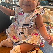 Genesis Rose is registered to the contest to win money with this photo: baby, child, smiling, dress, whale_pattern, sitting, sock, blanket, indoors, table, happy, cute, person, face, infant, playful, colorful, young, portrait, cozy