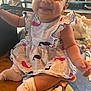 baby, child, smiling, dress, whale_pattern, sitting, sock, blanket, indoors, table, happy, cute, person, face, infant, playful, colorful, young, portrait, cozy