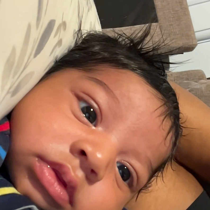 Kahryee joined the competition — help win amazing prizes! baby, infant, child, face, person, striped_clothing, indoor, couch, pillow, closeup, skin, hair, expression, video_call, technology, communication, relaxing, young, portrait, casual