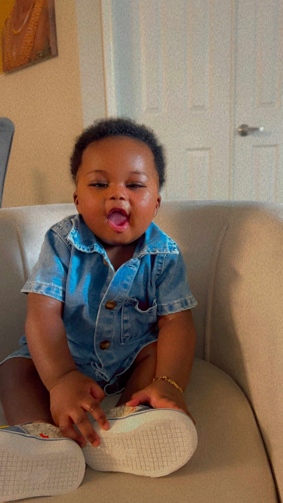 Joseph Fotsing joined the competition — help win amazing prizes! baby, child, denim_shirt, shoe, sitting, indoor, chair, happy, cute, toddler, person, smiling, short_hair, bracelet, footwear, home, casual_clothing, expression, skin, furniture