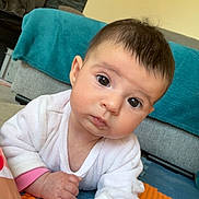 Luana participe au concours pour gagner de l'argent avec cette photo : baby, blanket, child, clothing, colorful, couch, crawling, curious, expression, eyes, face, floor, hand, head, indoor, infant, play_mat, portrait, skin, young
