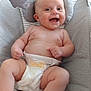 Charley is registered to the contest to win money with this photo: baby, smiling, diaper, baby_rocker, toy, soft_toy, cushion, infant, child, happy, indoors, person, cute, skin, chubby, comfort, seat, striped, face, hand