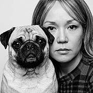 Mochi joined the competition — help win amazing prizes! pug, dog, woman, person, portrait, black_and_white, grayscale, close_up, face, eyes, hair, sweater, plaid, pet, companion, indoors, studio, serious, posed, photography