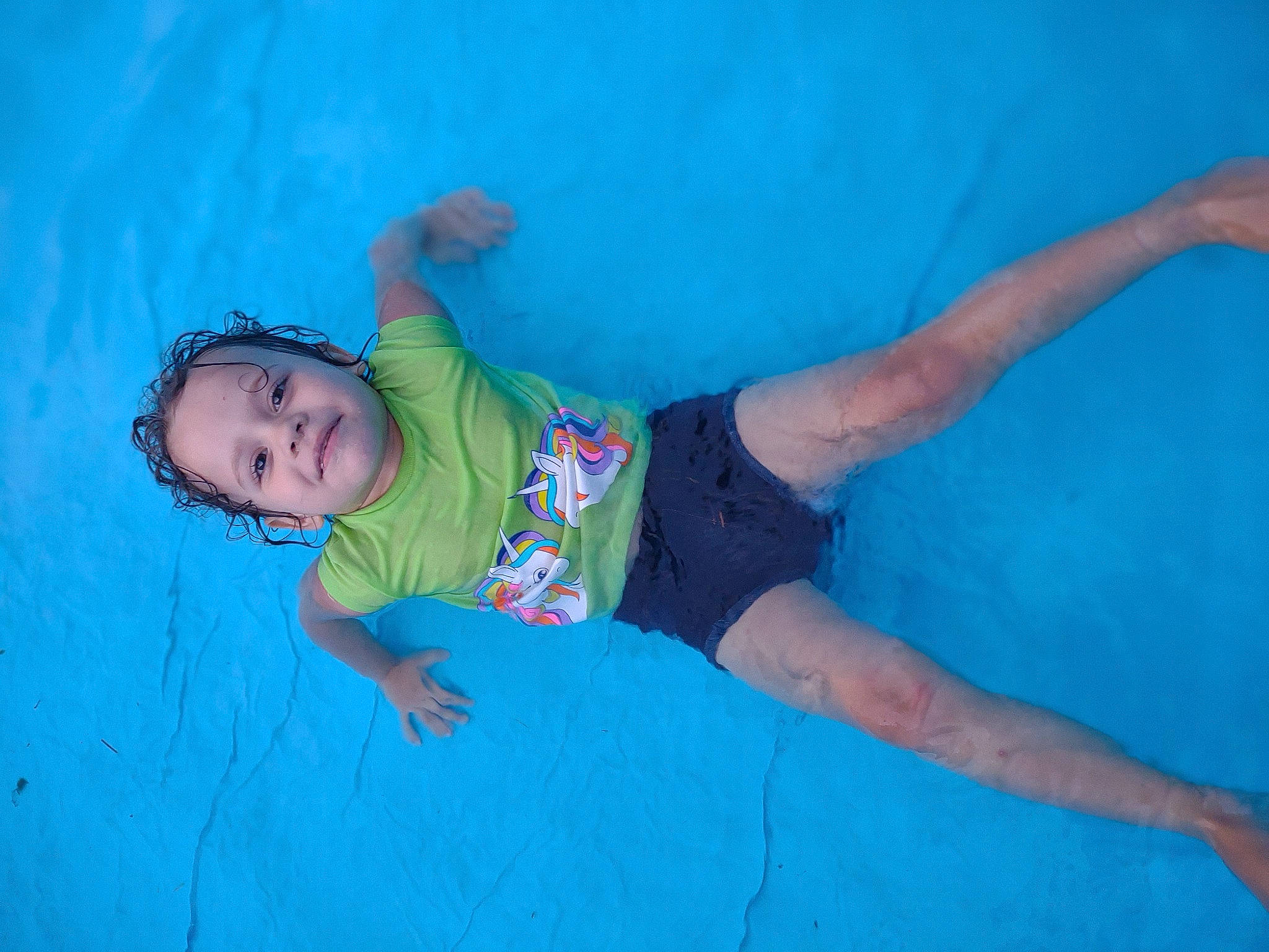 Lilly is registered to the contest to win money with this photo: azure, baby, baby_toddler_clothing, barefoot, child, elbow, electric_blue, flash_photography, fun, grass, happy, human_body, leisure, person, personal_protective_equipment, recreation, t_shirt, thigh, toddler, water