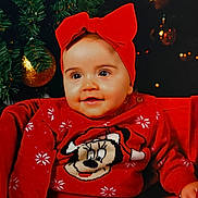 Ambre participe au concours pour gagner de l'argent avec cette photo : baby, celebration, child, christmas_tree, cute, decoration, festive, happy, headband, holiday, indoor, ornaments, person, portrait, red_bow, red_sweater, seasonal, sitting, smiling, white_pants