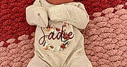 Sadie is registered to the contest to win money with this photo: baby, bow, child, clothing, cozy, cream, cute, headband, indoors, infant, lying_down, newborn, pattern, pink, portrait, red, rug, sleeping, soft, textile