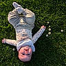baby, cheeks, child, collar, cute, daisy, flower, grass, greenery, happy, infant, long_sleeve, lying_down, nature, outdoor, pants, portrait, smile, socks, sunlight