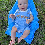 Ryder is registered to the contest to win money with this photo: baby, barefoot, blue_blanket, blue_eyes, clothing, cute, grass, happy, infant, natural_light, outdoor, overalls, person, portrait, puppy_patches, sitting, skin, smiling, summer, young_child