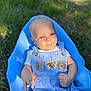Ryder is registered to the contest to win money with this photo: baby, blanket, blue_eyes, child, cute, grass, hands, head, infant, nature, outdoor, overalls, portrait, puppy_patches, relaxed, sitting, skin, smiling, sunlight, wearing_clothes