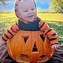 baby, pumpkin, jack_o_lantern, smiling, hoodie, orange, black, outdoor, grass, lake, trees, fall, seasonal, holiday, cute, child, face, happy, nature, costume