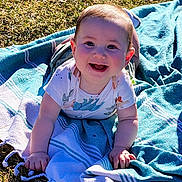 Ethan joined the competition — help win amazing prizes! baby, infant, smile, drool, blue_blanket, blanket, grass, outdoors, sunshine, portrait, hands, face, cheeks, ears, eyes, crawling_position, clothing, tassel, picnic, happy