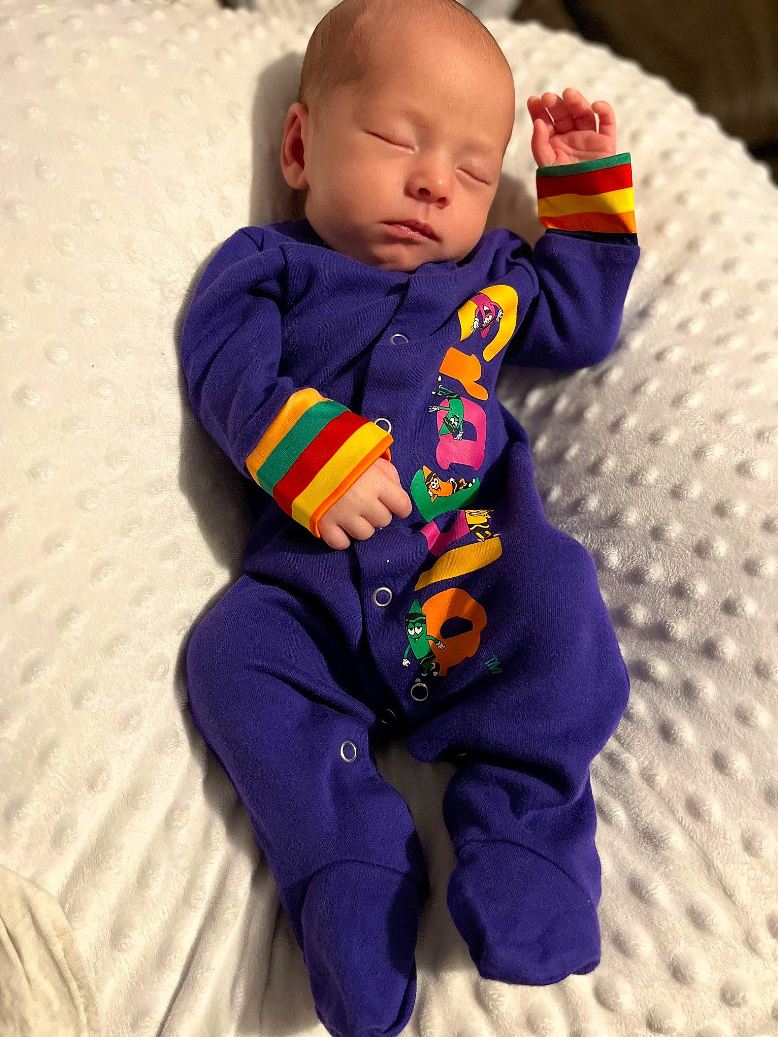 Jonas is registered to the contest to win money with this photo: baby, baby_products, baby_toddler_clothing, child, comfort, electric_blue, eye, face, flooring, fun, happy, human_body, linens, magenta, pattern, person, purple, sitting, sleeve, t_shirt