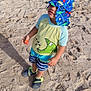 Pedro is registered to the contest to win money with this photo: beach, blue, casual_clothing, child, food, footwear, green, hat, outdoor, playful, sand, shadow, strawberry, striped_shorts, summer, sunhat, sunlight, swimwear, toddler, young_child