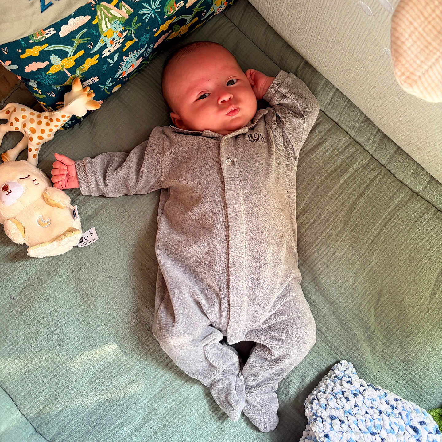 Léon a rejoint le concours — aidez-le/la à gagner de superbes lots ! baby, infant, onesie, plush_toy, giraffe_toy, pillow, quilt, blanket, face, expression, bed, sleepwear, child, cute, indoor, cozy, nursery, soft_toys, resting, person