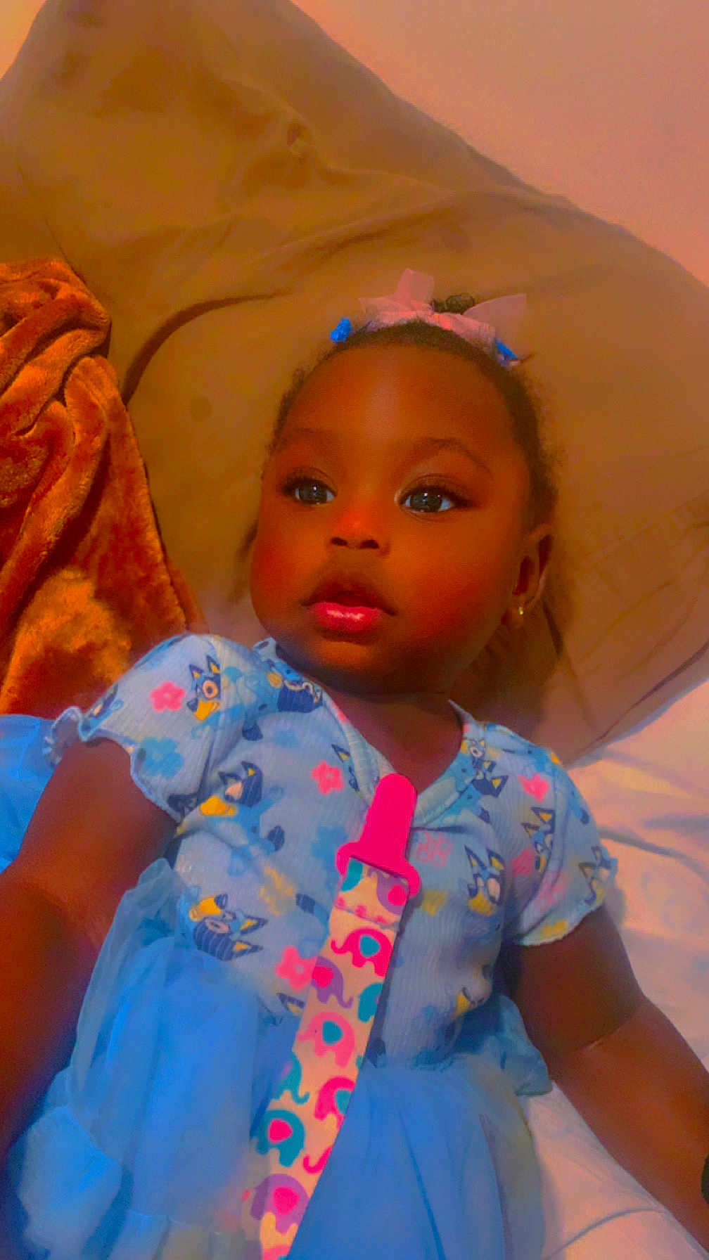 Miracle joined the competition — help win amazing prizes! toddler, child, baby, blue_dress, pacifier_clip, bed, blanket, curly_hair, earrings, cute, indoor, portrait, relaxed, sleepwear, soft_toys, colorful, smiling, face, person, young