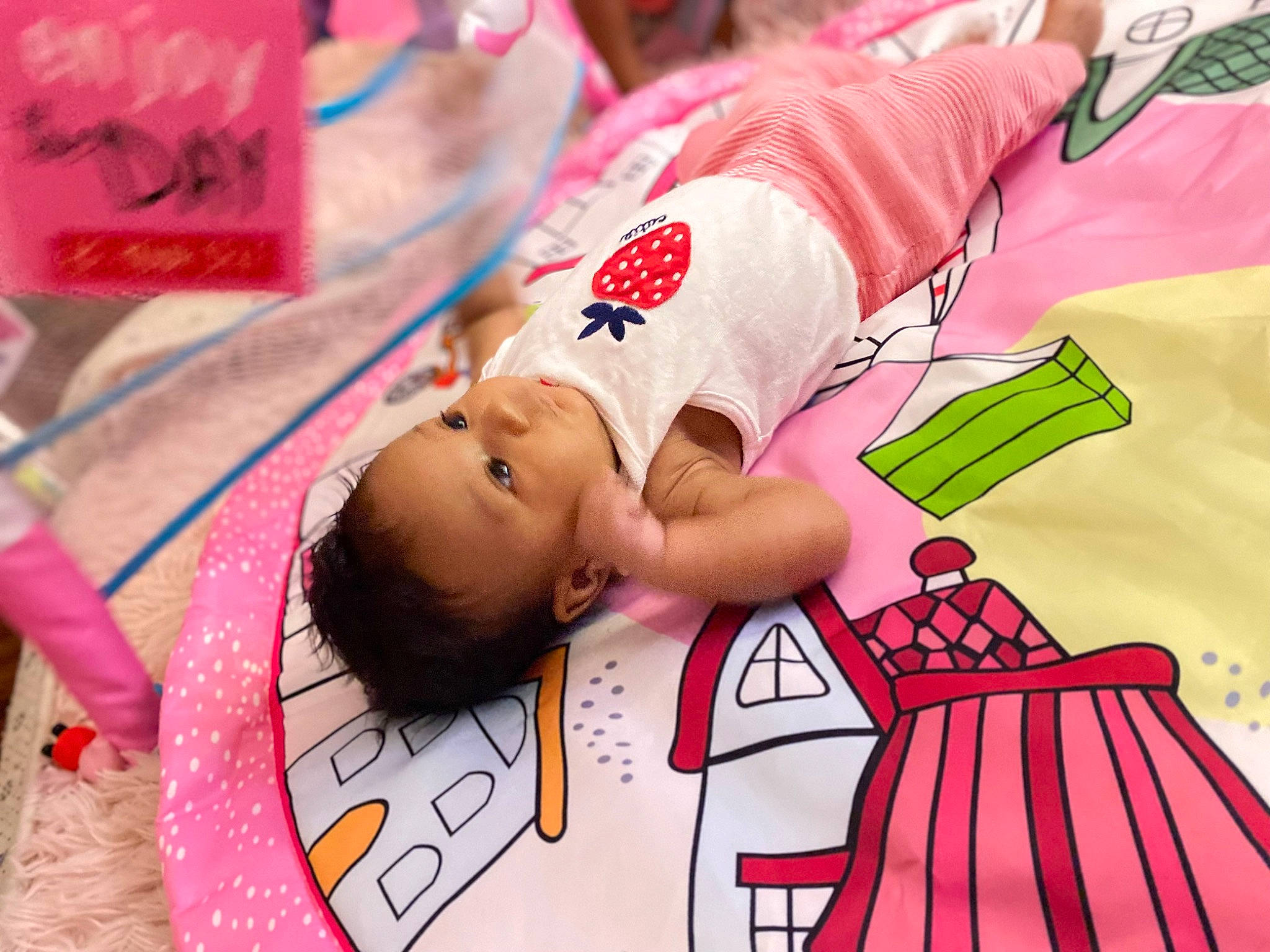 Ariyah is registered to the contest to win money with this photo: baby, carmine, child, event, flooring, fun, happy, leisure, linens, magenta, mammal, pattern, person, pink, play, product, red, sleeve, t_shirt, toddler