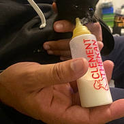 Baghéra a rejoint le concours — aidez-le/la à gagner de superbes lots ! kitten, black_cat, bottle, bottle_feeding, hand, human_hand, feeding, milk, newborn, pet, indoor, hoodie, close_up, blurry_background, couch, small_animal, adorable, warm_lighting, person, bottle_nipple