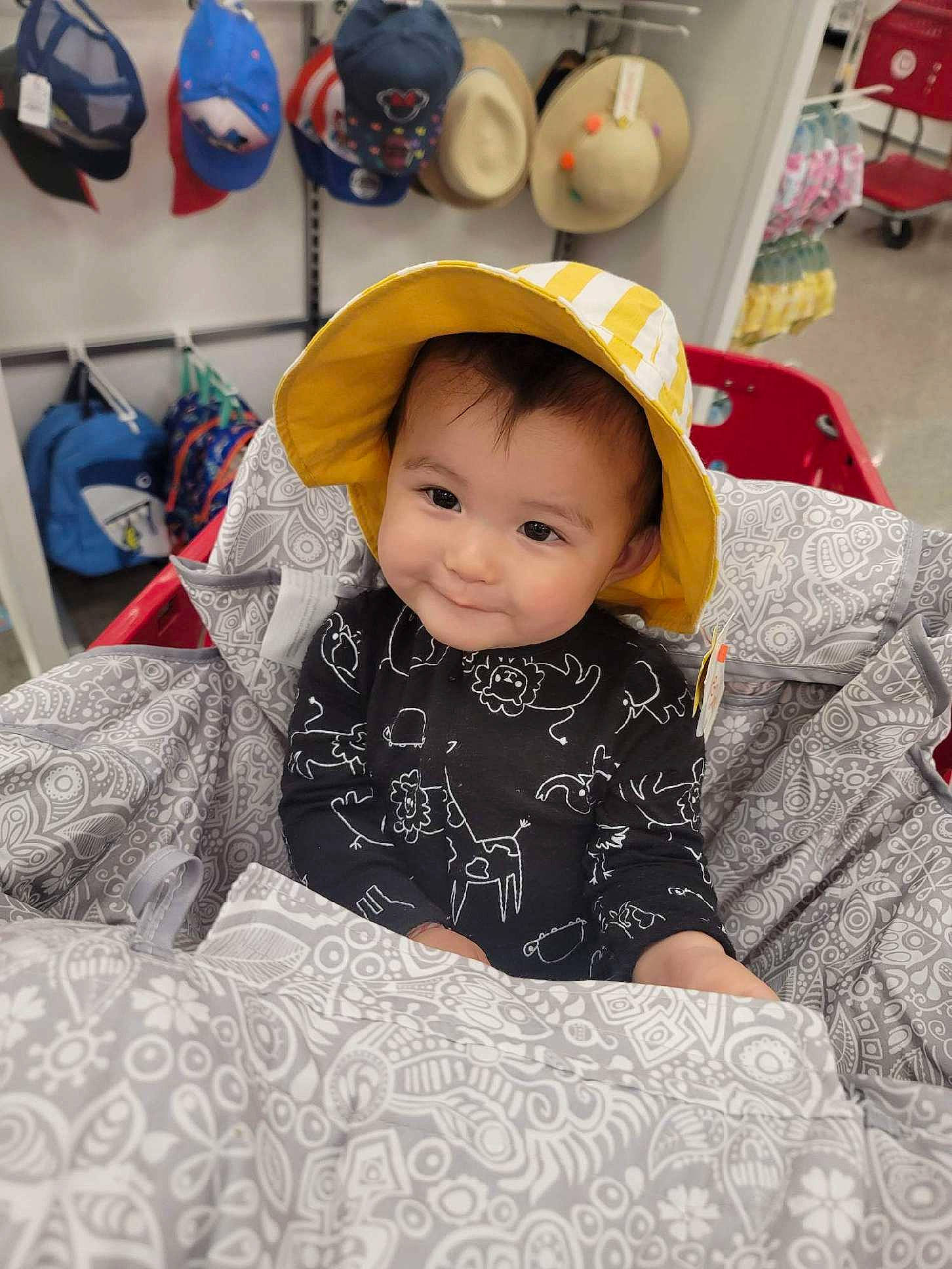 Jia is registered to the contest to win money with this photo: baby, baby_toddler_clothing, cap, child, comfort, fashion_accessory, fun, happy, hat, joy, kitchen_appliance, linens, person, play, room, sitting, sleeve, smile, sun_hat, t_shirt