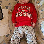 Corsen joined the competition — help win amazing prizes! baby, infant, smiling, red_sweatshirt, gray_pants, arrows, blanket, teddy_bear_pattern, stars, socks, cozy, cute, child, young_child, indoors, portrait, lying_down, clothing, happy, face